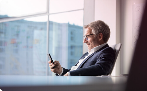 Mann sitzt auf einem Stuhl im Büro und benutzt Business App