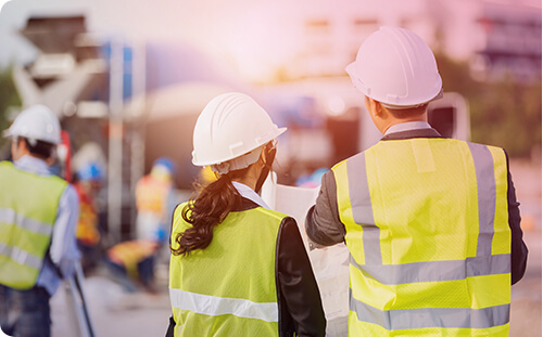 Frau und Mann prüfen Baustelle