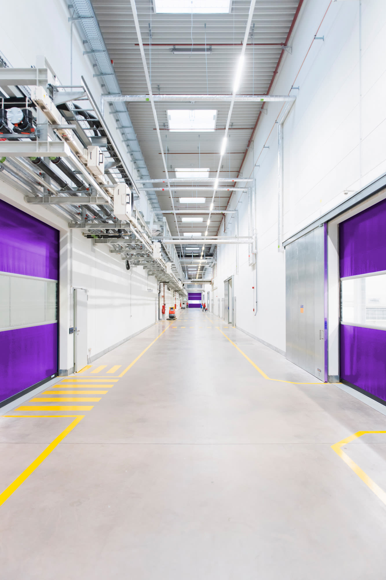 Sodoben industrijski hodnik z vijoličastimi vrati - v prihodnost usmerjena infrastruktura v podjetju BKS.