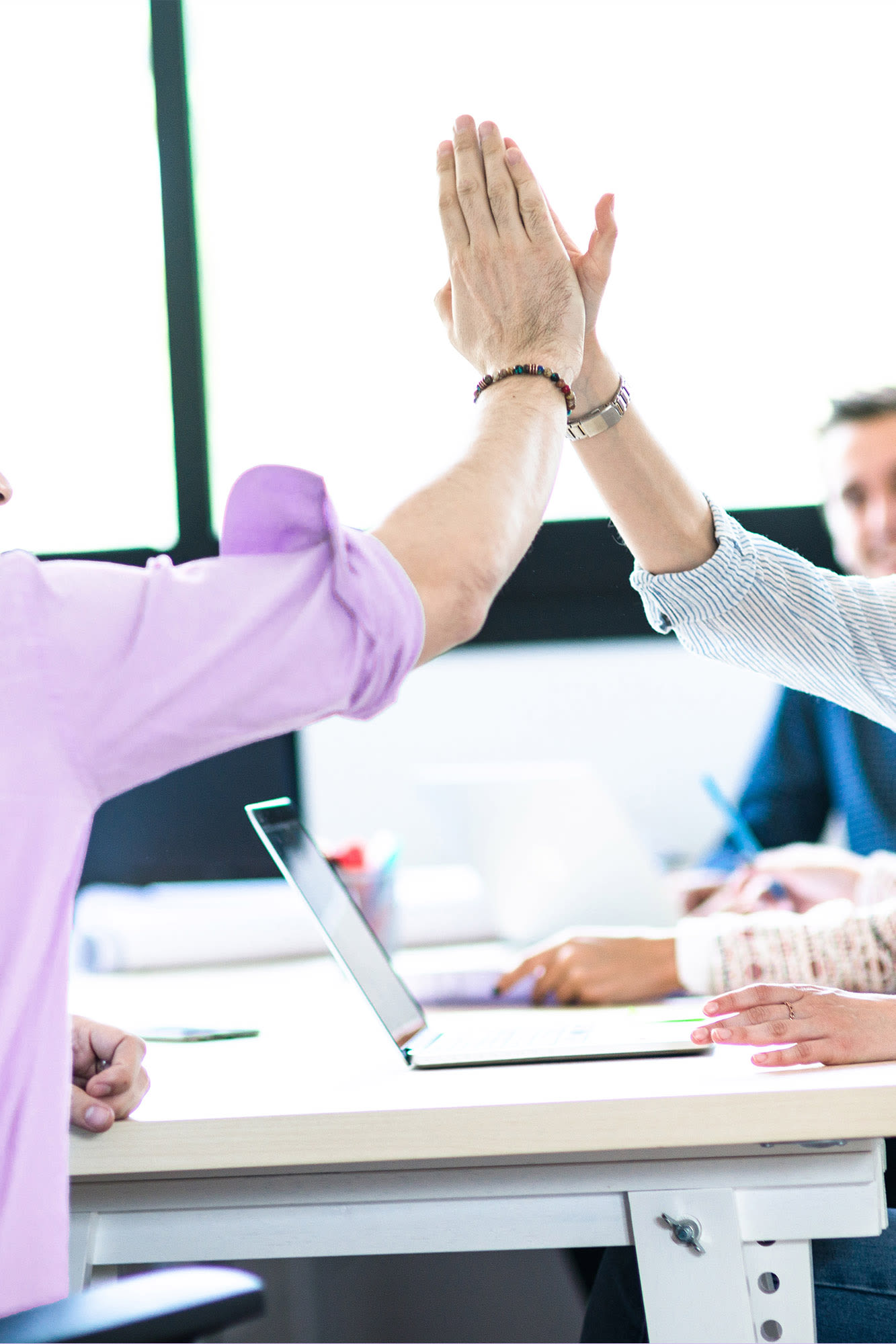 Dva sodelavca si v pisarni dasta petko - uspešno timsko delo v družbi BKS.