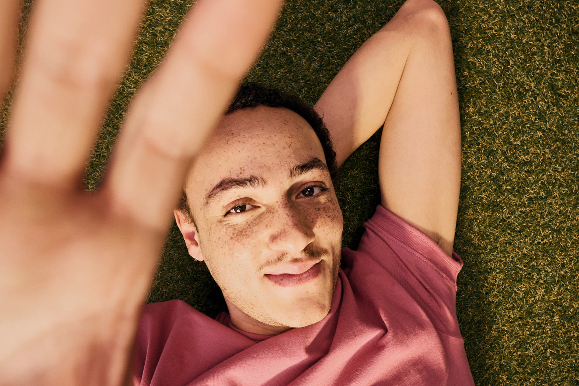 Moški sproščeno leži na travniku - trajnostni življenjski slog in ozaveščenost o podnebju.