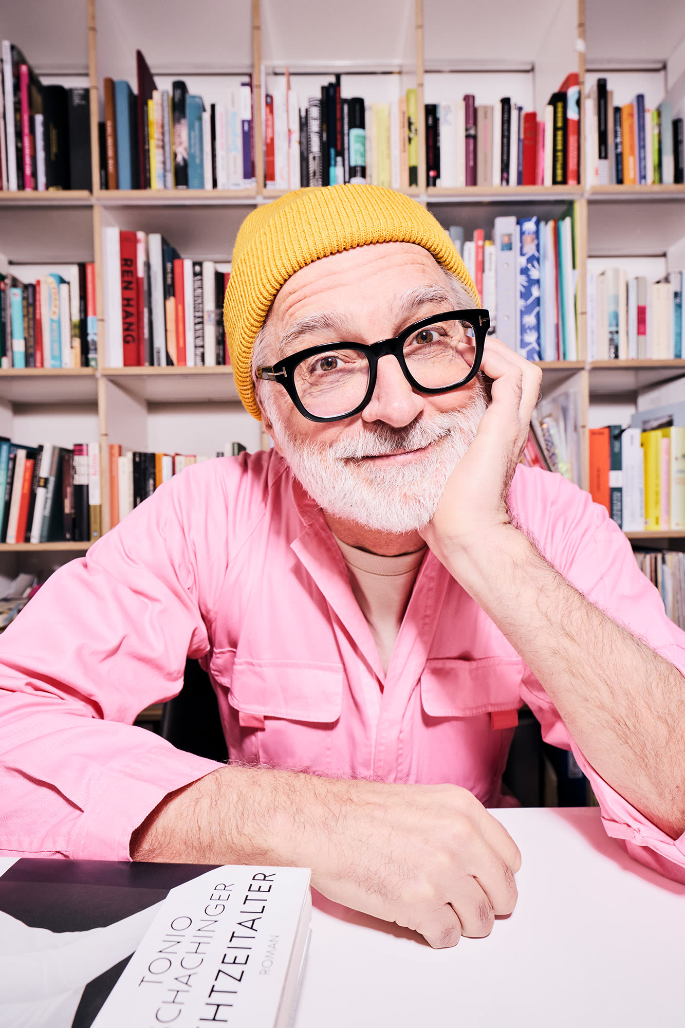 Moški v rožnati srajci pred knjižno polico - klasične oblike naložb za medgeneracijsko bogastvo