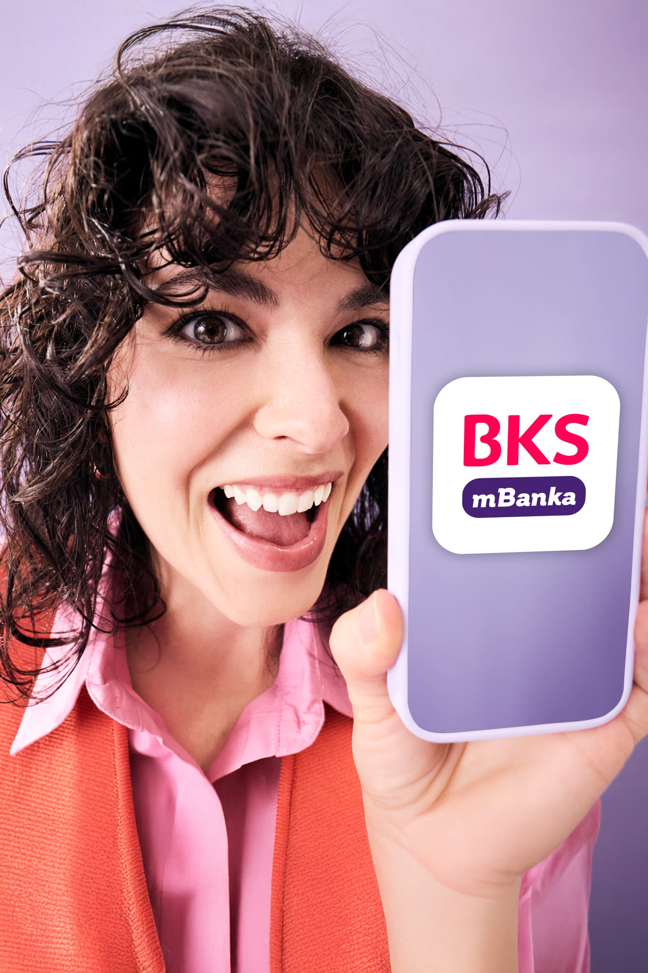 Nasmejana oseba drži pametni telefon z aplikacijo BKS mBanka – sodoben in varen način za hitro upravljanje financ kjerkoli in kadarkoli. Svetla in energična podoba digitalnega bančništva.