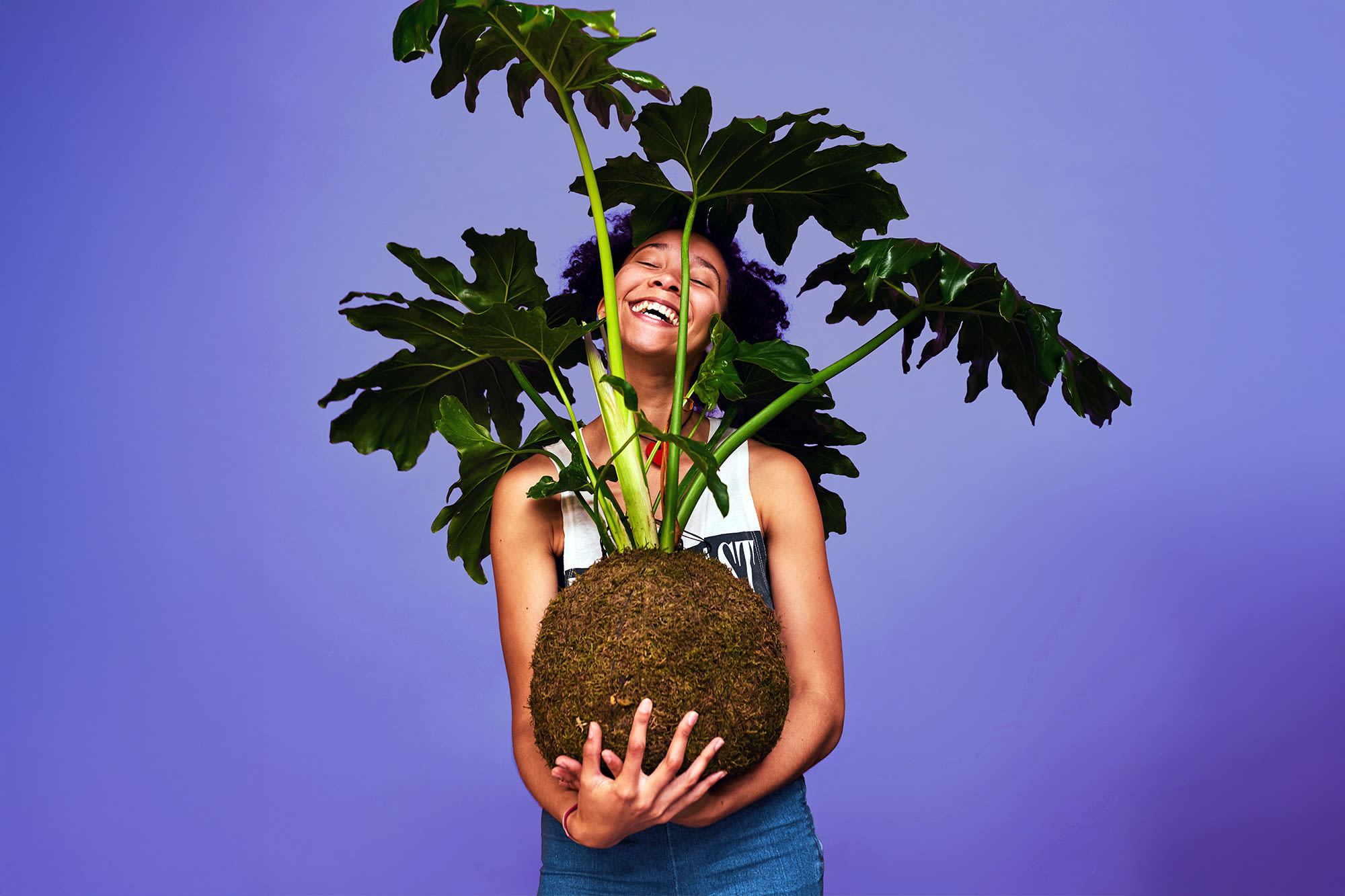 Nasmejana ženska z veliko rožo v naročju, ki raste. BKS varčevanje za jutri. Nasmejana ženska z veliko rožo v naročju, ki raste. BKS varčevanje za jutri.