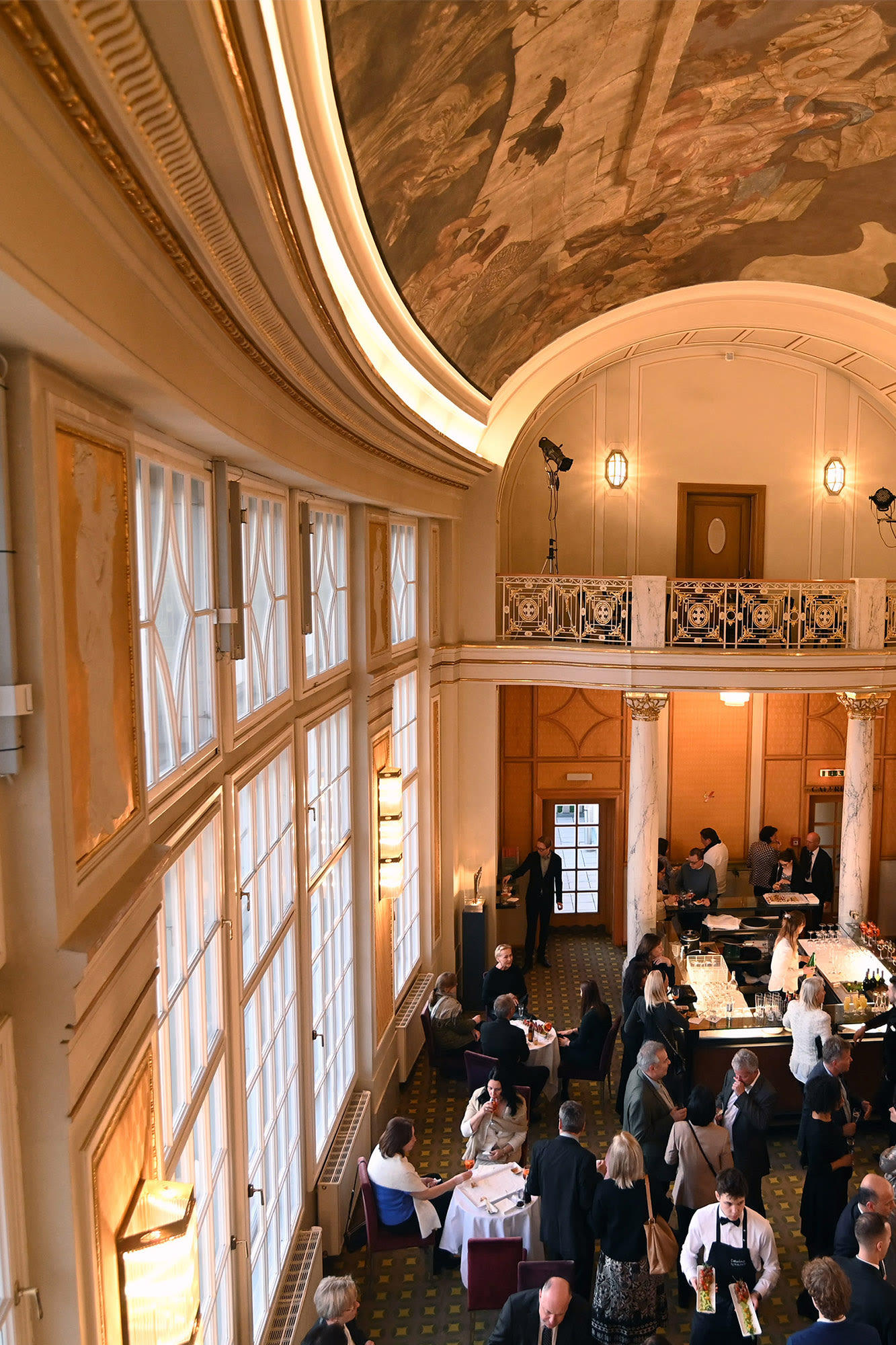 Saal mit vielen Menschen in formeller Kleidung.