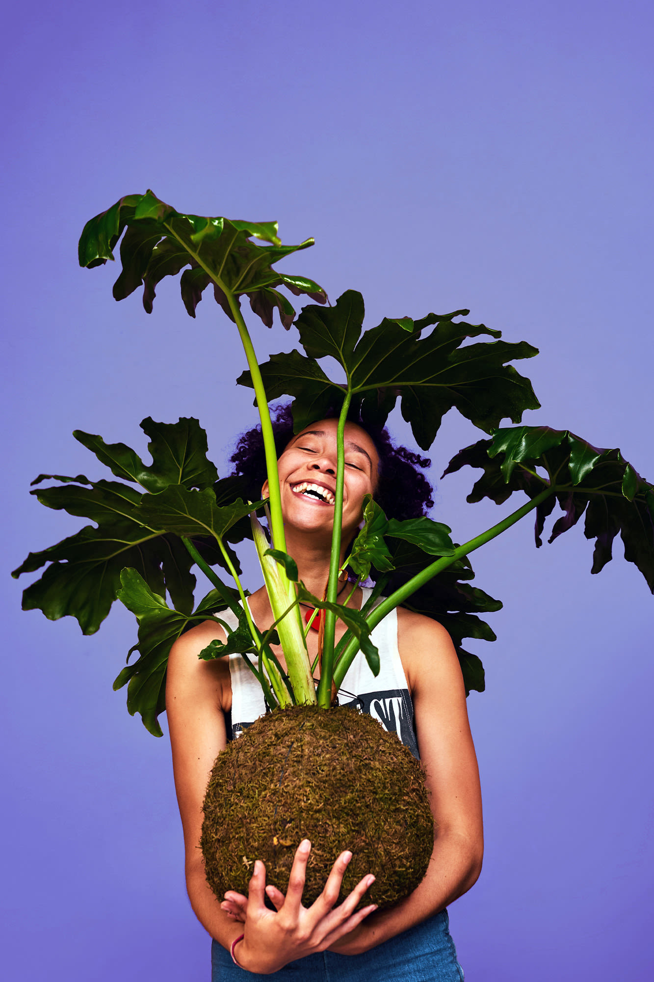 Nasmejana ženska z veliko rožo v naročju, ki raste. BKS varčevanje za jutri.