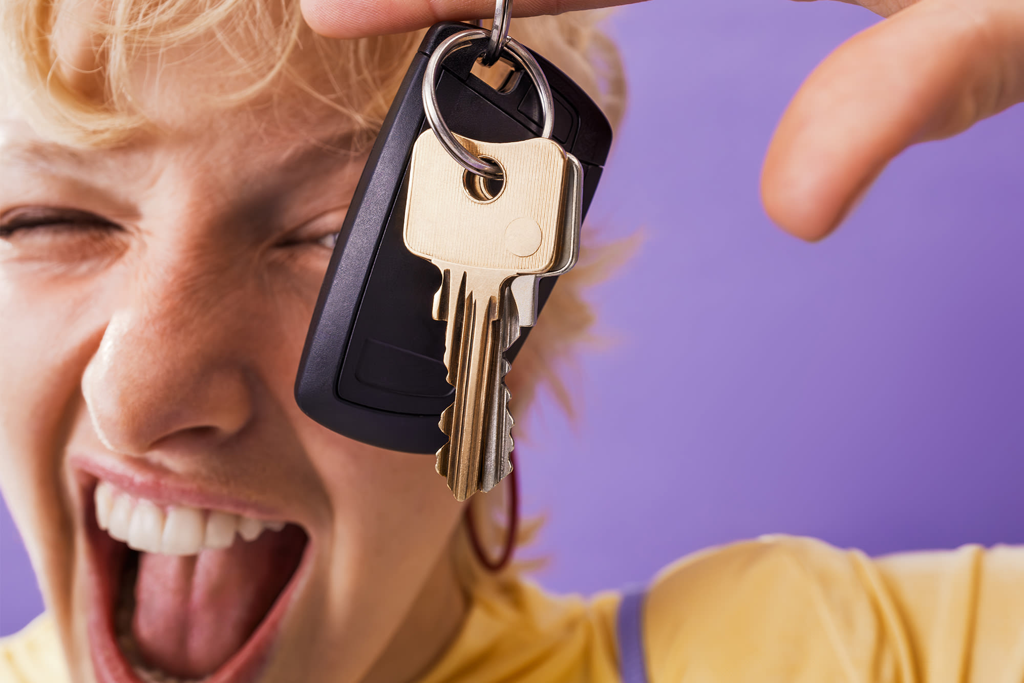 Ženska z avtomobilskim ključem, pred vijoličnim ozadjem. Ženska z avtomobilskim ključem, pred vijoličnim ozadjem.