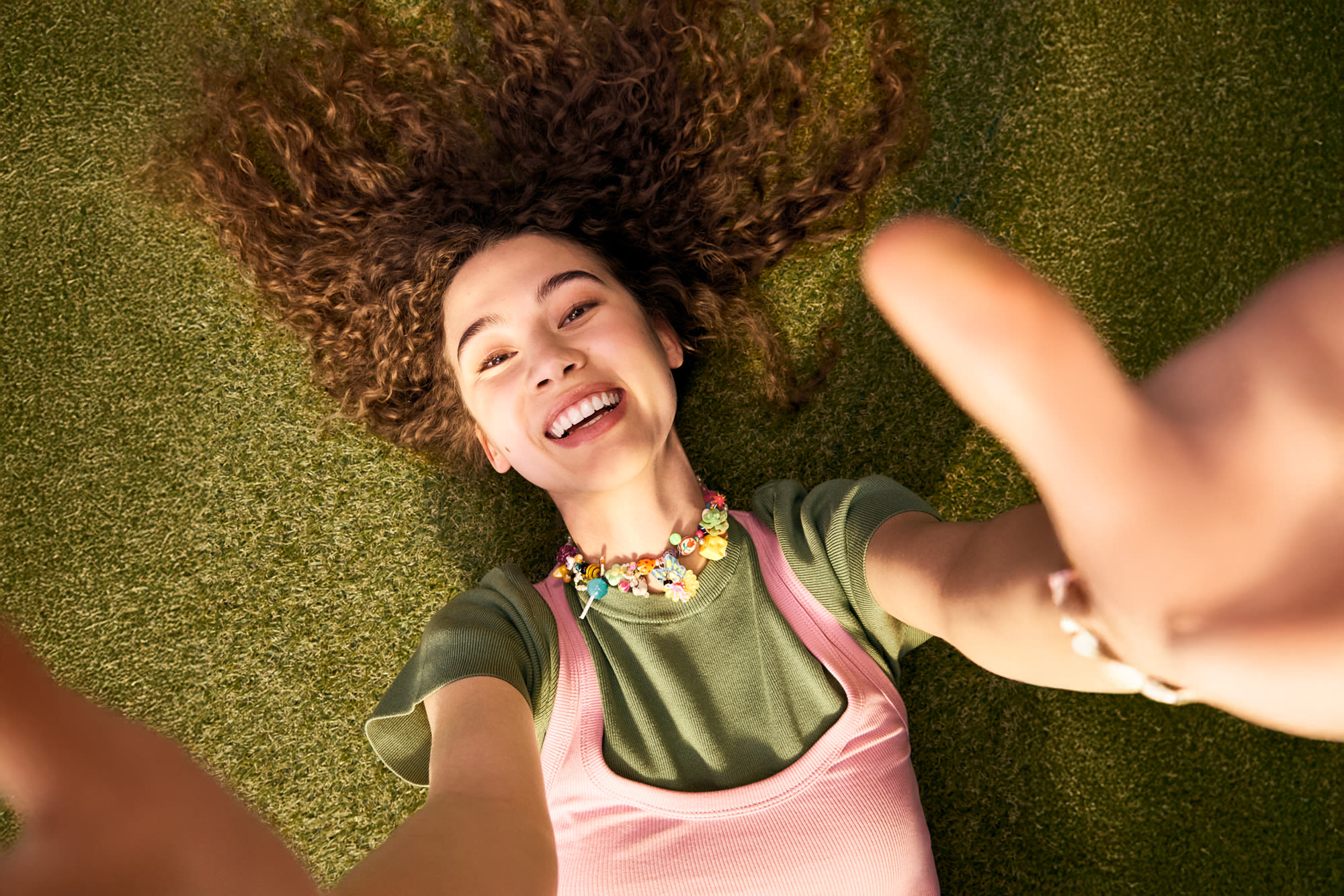 Dekle z nasmehom iztegne roke - trajnostno življenje z navdušenjem v banki BKS.