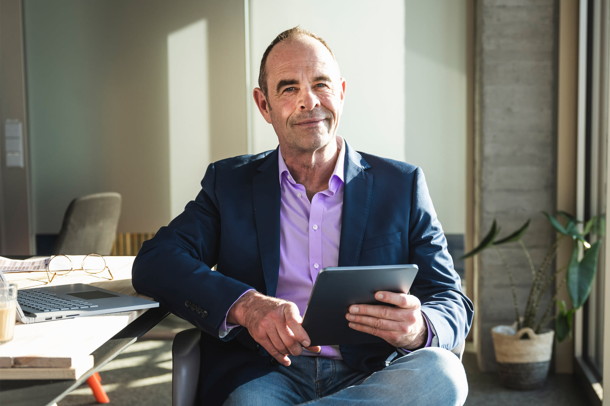 Moški v pisarni s tabličnim računalnikom - soliden poslovni račun za podjetnike z BKS Business Premium.