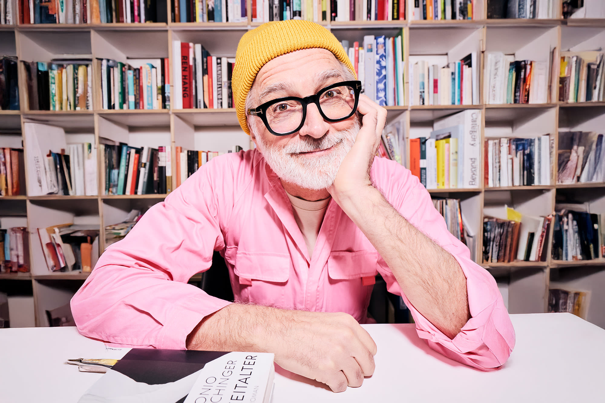 Moški v rožnati srajci pred knjižno polico - klasične oblike naložb za medgeneracijsko bogastvo