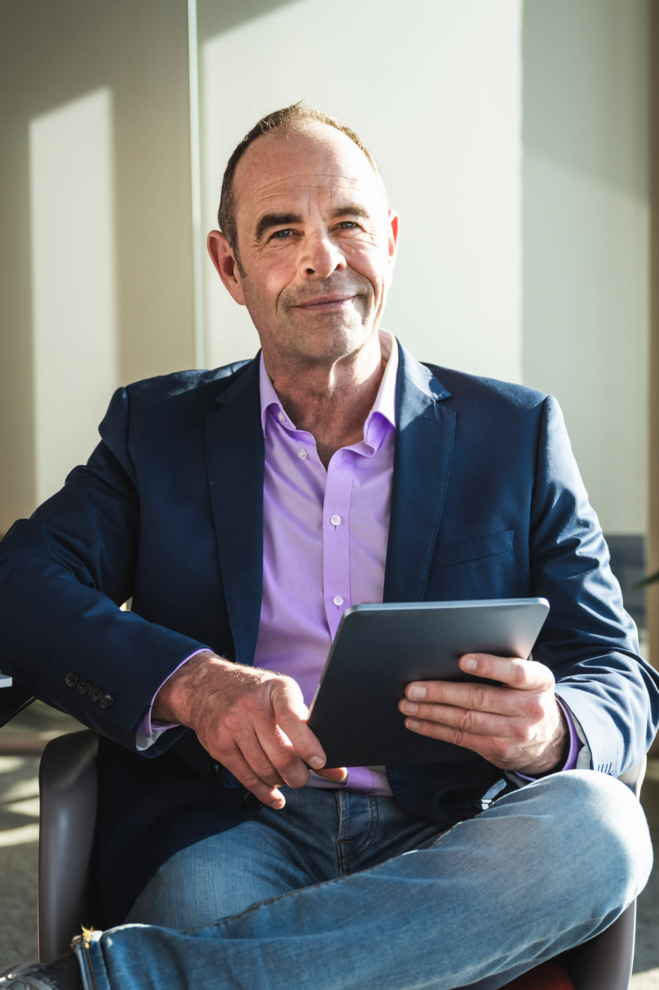 Moški v pisarni s tabličnim računalnikom - soliden poslovni račun za podjetnike z BKS Business Premium.