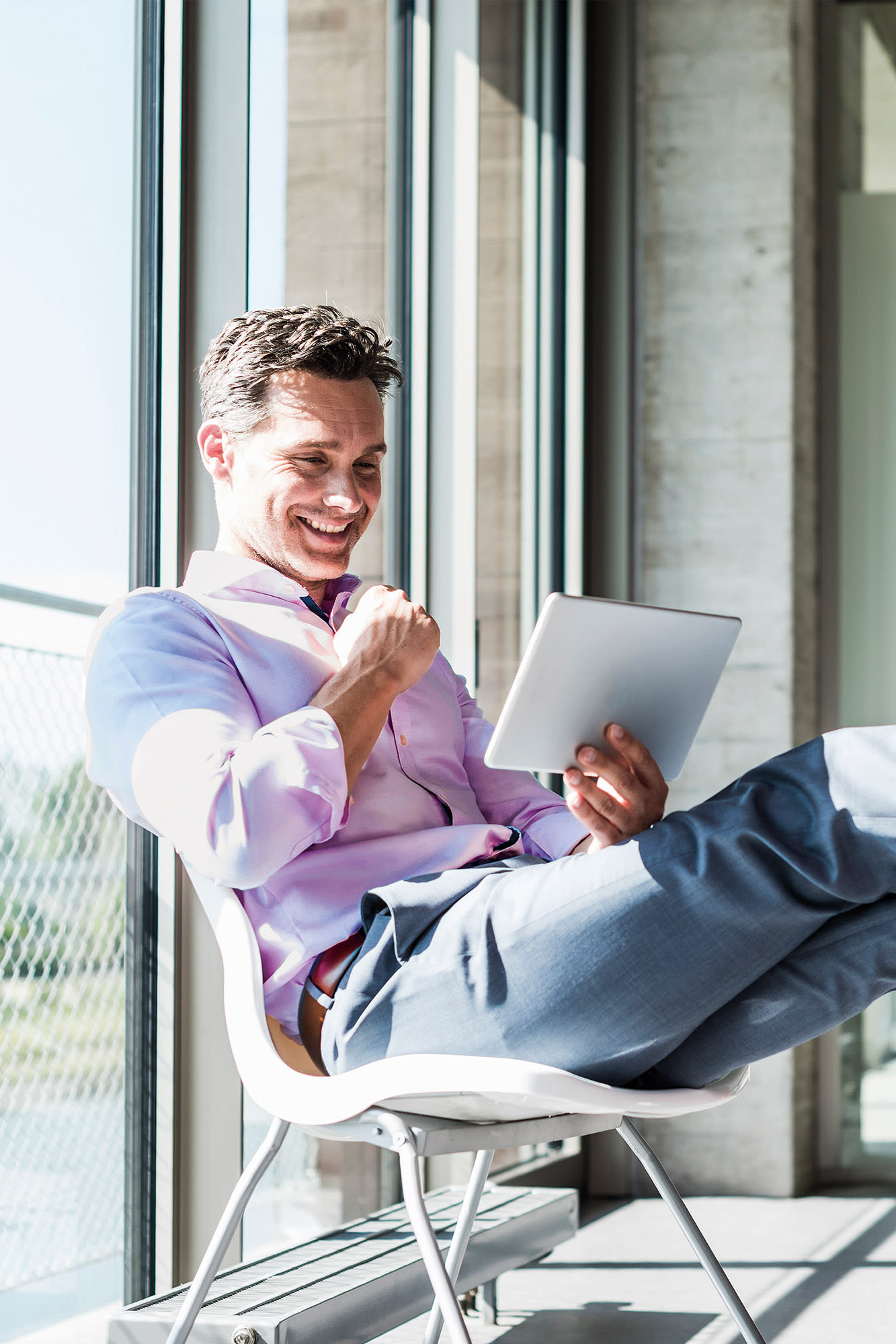 Moški v rožnati majici gleda na tablični računalnik - Elba BKS Bank