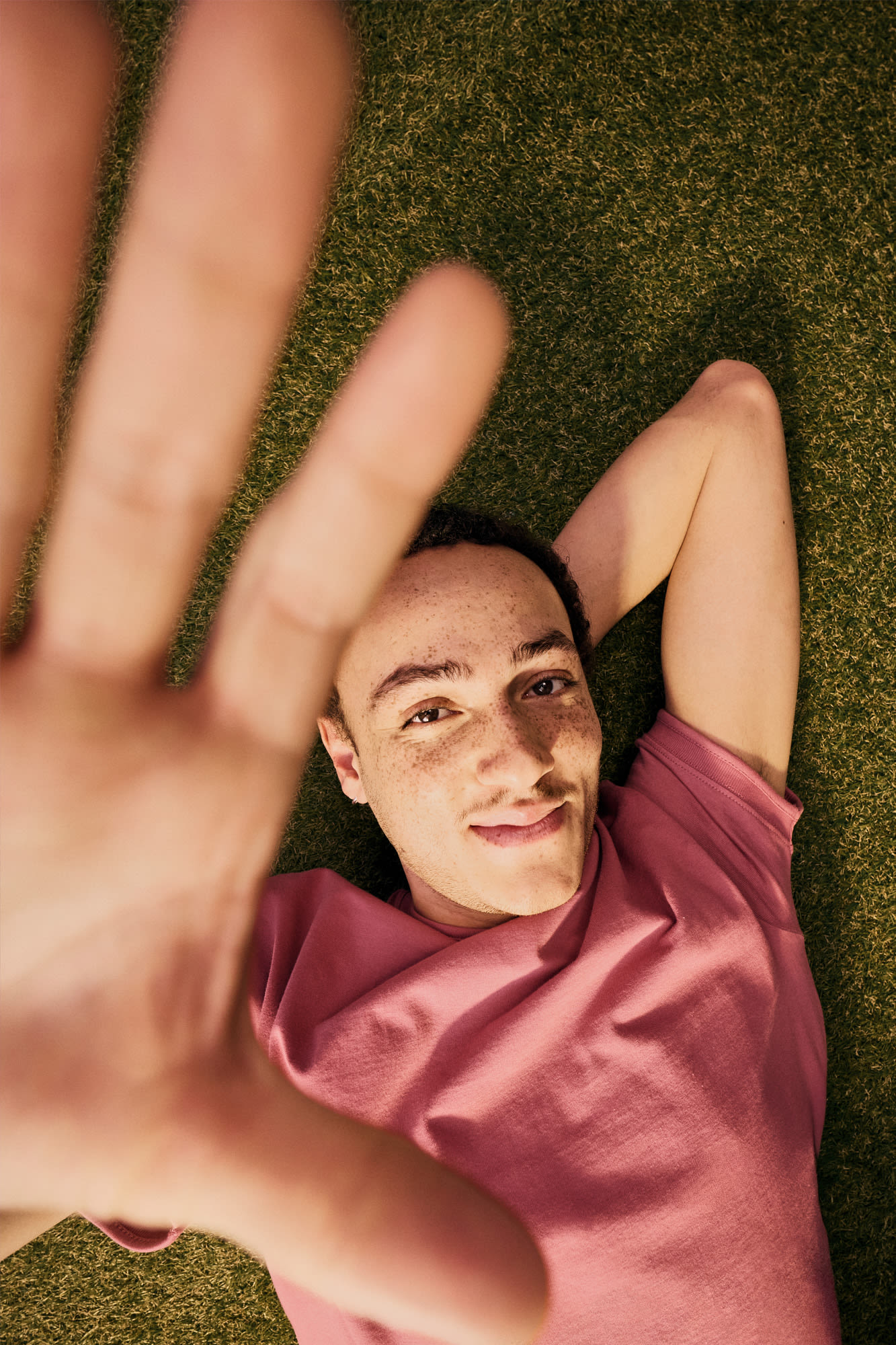 Moški sproščeno leži na travniku - trajnostni življenjski slog in ozaveščenost o podnebju.