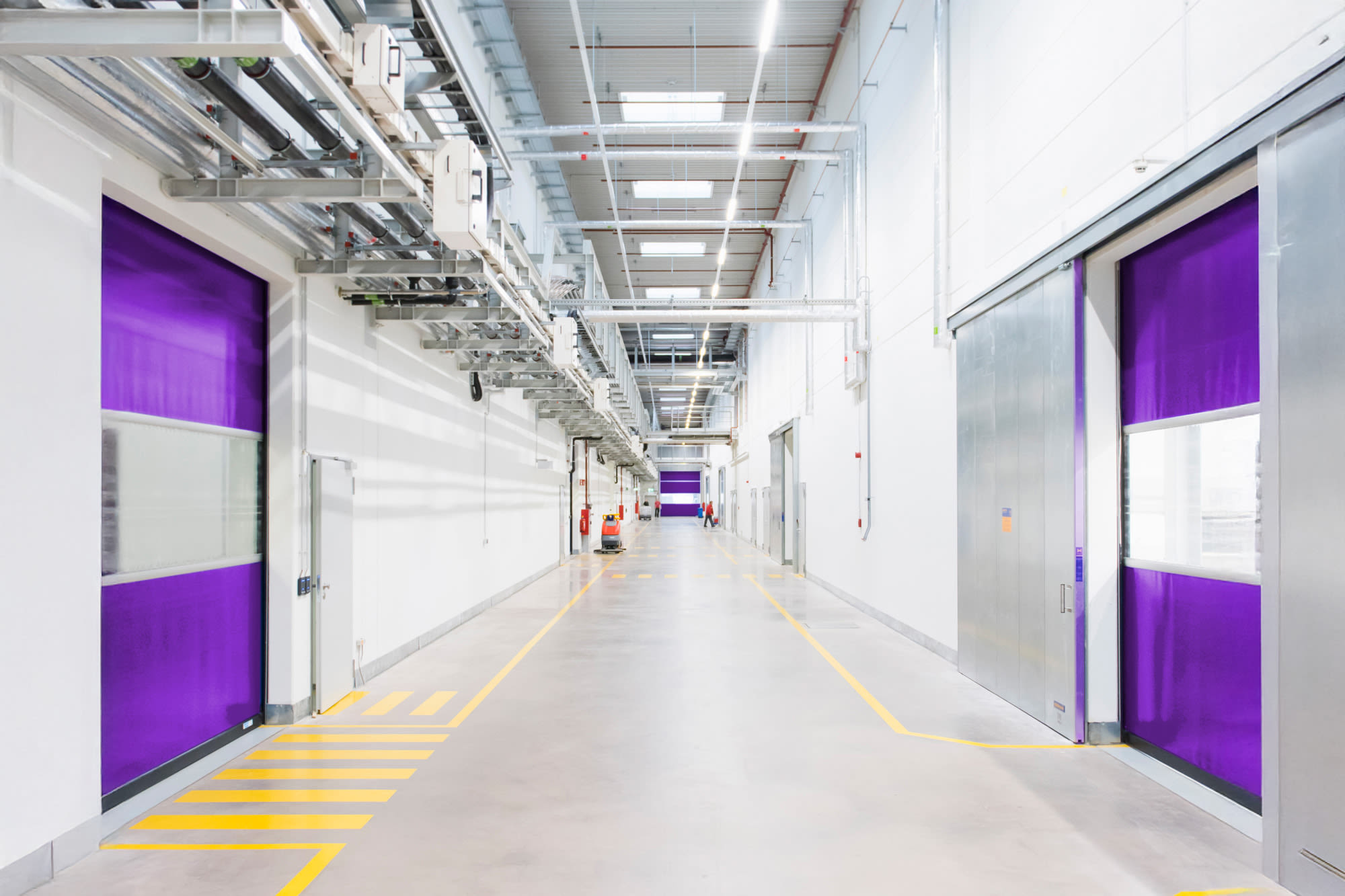 Sodoben industrijski hodnik z vijoličastimi vrati - v prihodnost usmerjena infrastruktura v podjetju BKS. Sodoben industrijski hodnik z vijoličastimi vrati - v prihodnost usmerjena infrastruktura v podjetju BKS.